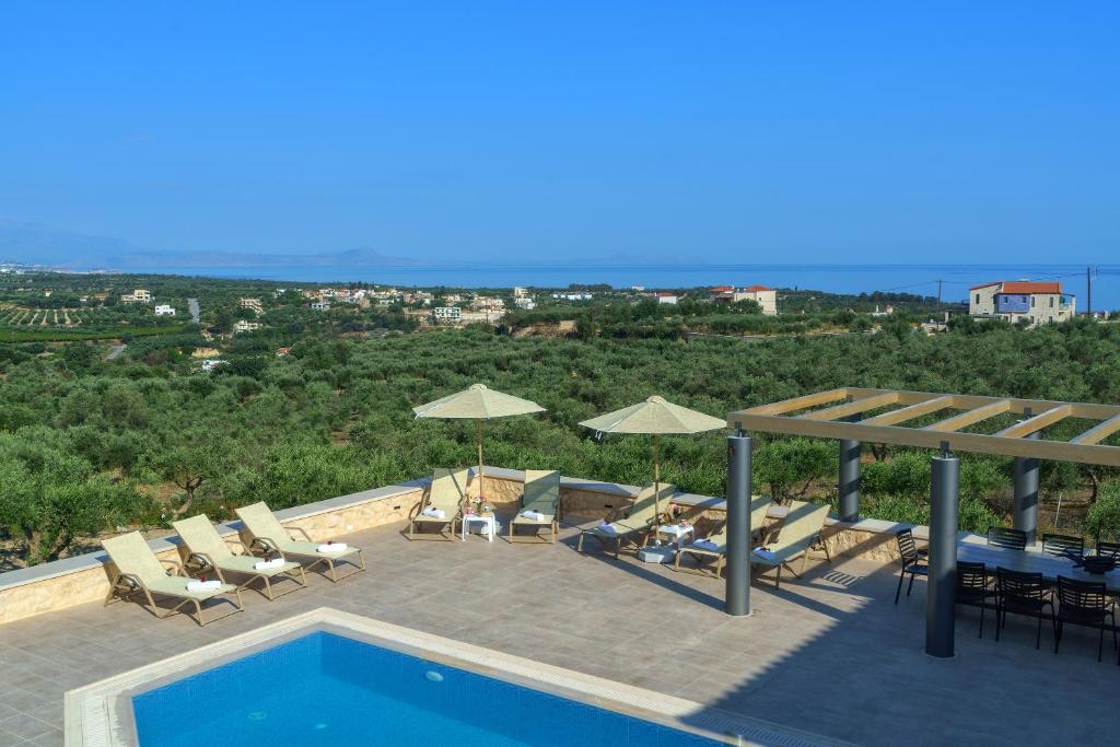 阿斯特里昂Luxury Villa Aria with Pool & Children's Area, 5km to Beach!的美景庭院内一个带椅子和遮阳伞的游泳池
