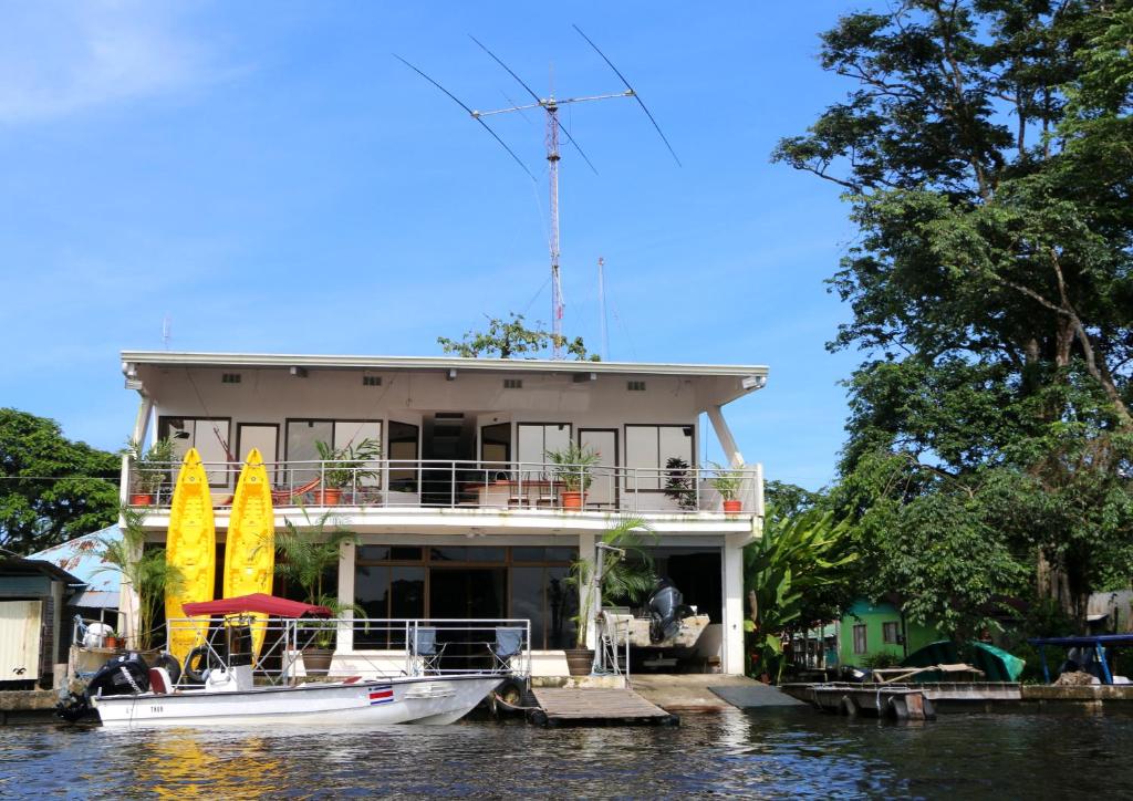 托尔图格罗Tortuguero Adventures GuestHouse的船停靠在水面上的房子前面