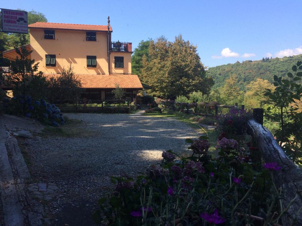 BorzonascaAgriturismo LA TAVERNA DEL NONNO的一座带花园的房屋,前面有鲜花