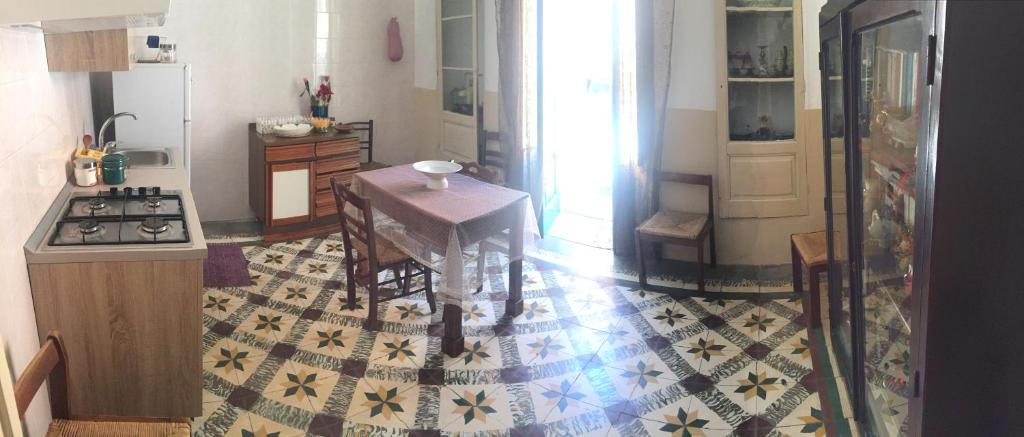 库特罗菲安诺Nel Cuore del Salento的一间带桌子的厨房和一间带炉灶的厨房