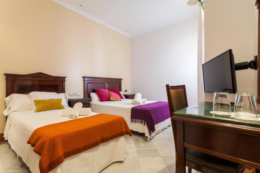 塞维利亚巴克酒店的酒店客房设有两张床和电视。