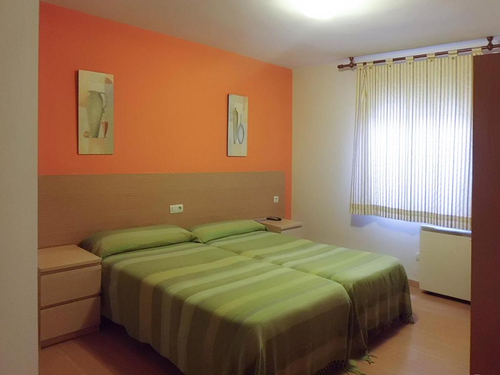 拉林Hostal Caracas的一间卧室配有一张橙色墙壁的床
