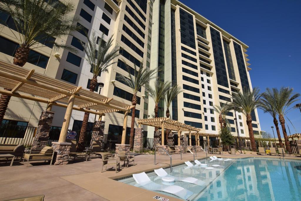 拉斯维加斯拉斯维加斯伯克利公寓式酒店的一座带游泳池、棕榈树和大楼的度假村