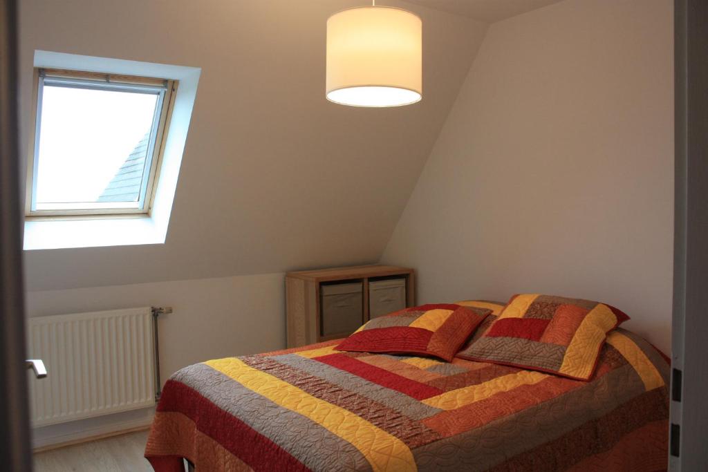 希伯维列Gite Le coeur des Ribeaupierres的一间卧室配有一张带彩色毯子的床