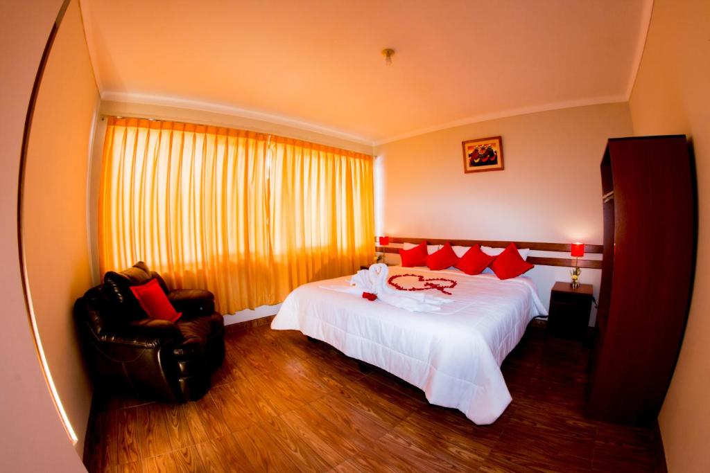 库斯科Cusco House的卧室配有一张白色大床和一把椅子