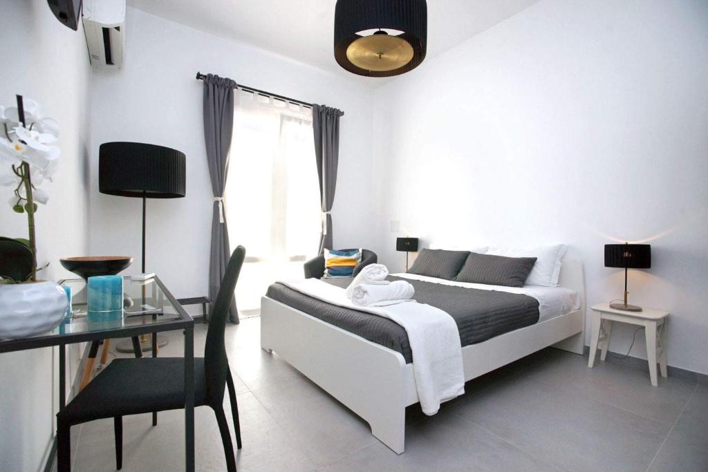 诺托B&B Roda Barocco的卧室配有白色的床、桌子和书桌