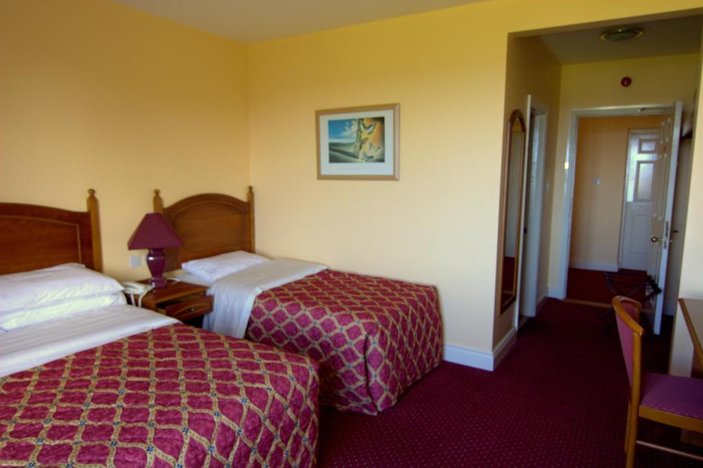 Achill SoundLavelle's Seaside House & Mickey's Bar的酒店客房设有两张床和一张带台灯的桌子。