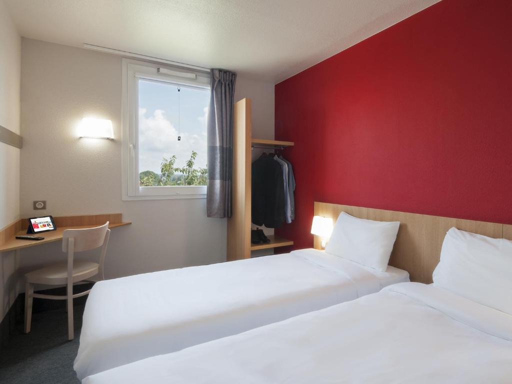帕雷·勒·毛尼尔B&B HOTEL Paray-le-Monial的酒店客房设有两张床和窗户。