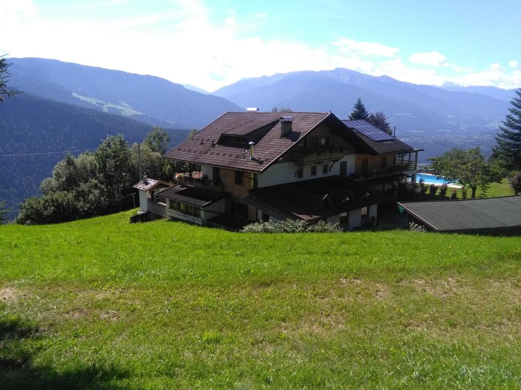 马兰扎Pension Marianne的坐落在绿色山丘顶部的房子