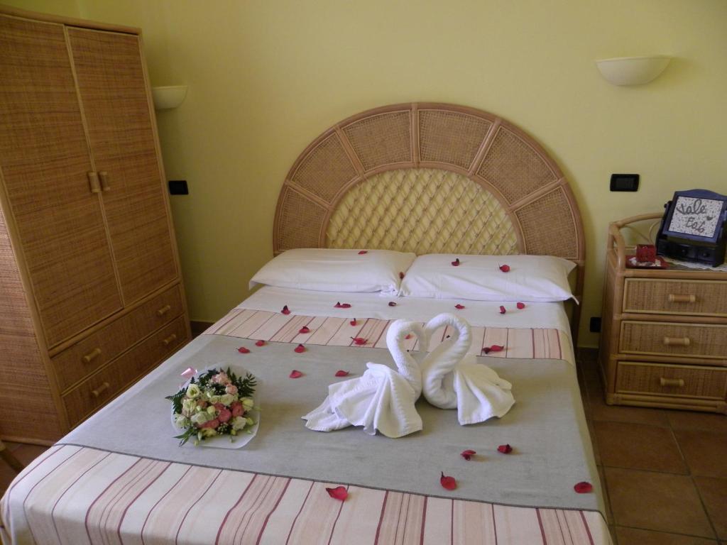 因佩里亚Soggiorno Marino San Giuseppe的一间卧室,床上有玫瑰花床