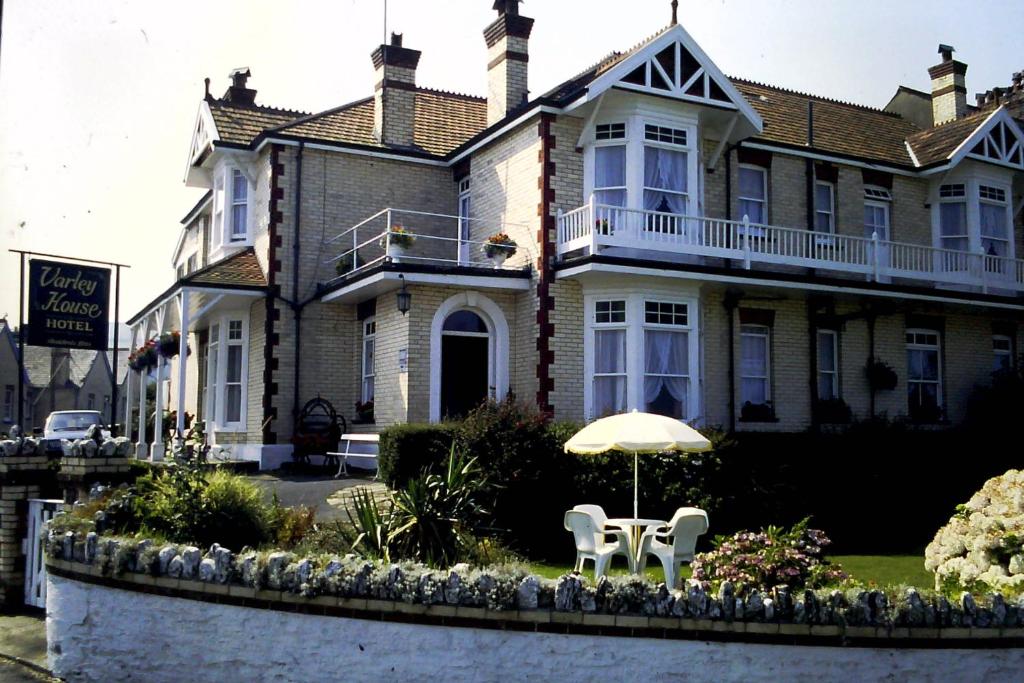 伊尔弗勒科姆瓦利屋酒店的前面有桌子和雨伞的房子