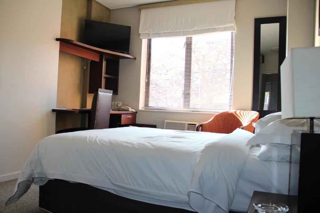 约翰内斯堡伊洛沃酒店的卧室配有白色的床和窗户。
