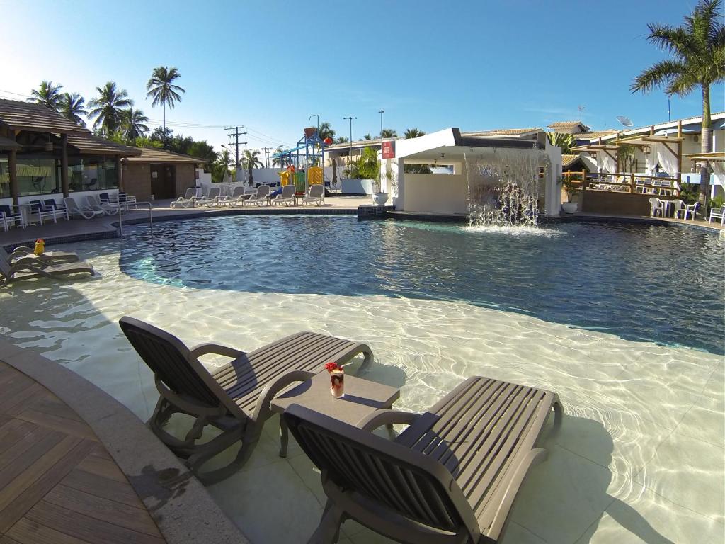 塞古罗港Sueds Plaza的一个带两把椅子的游泳池和一个喷泉
