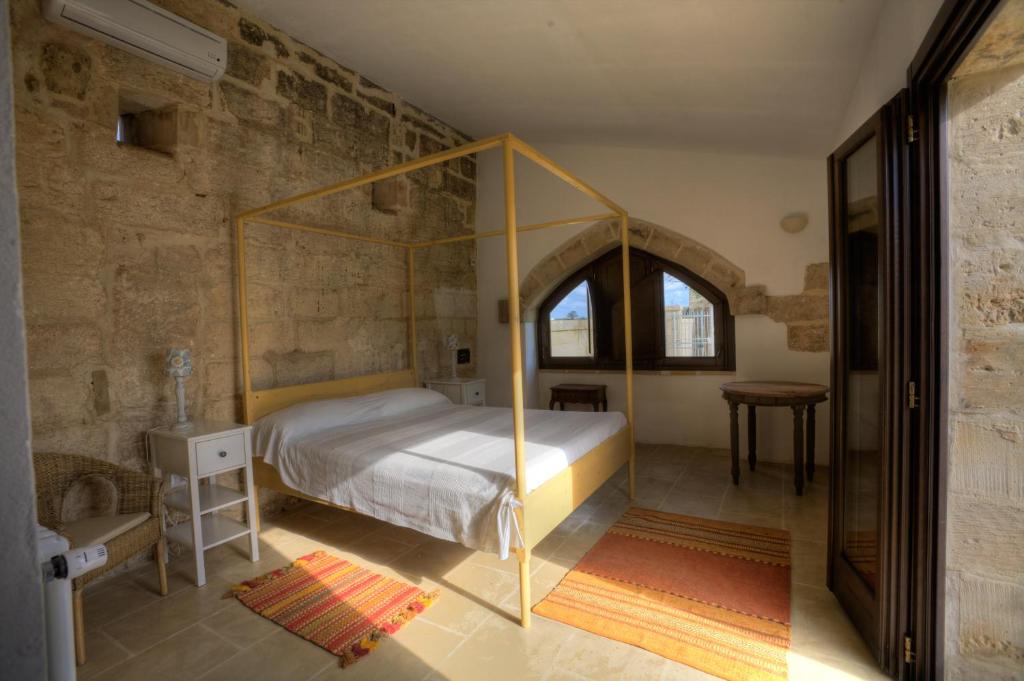 穆罗莱切塞马塞里亚拉哥酒店的大楼内一间卧室,配有一张天蓬床