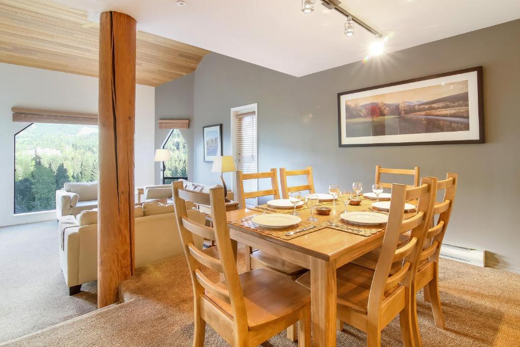 惠斯勒Snowbird by Elevate Vacations的用餐室以及带木桌和椅子的客厅。