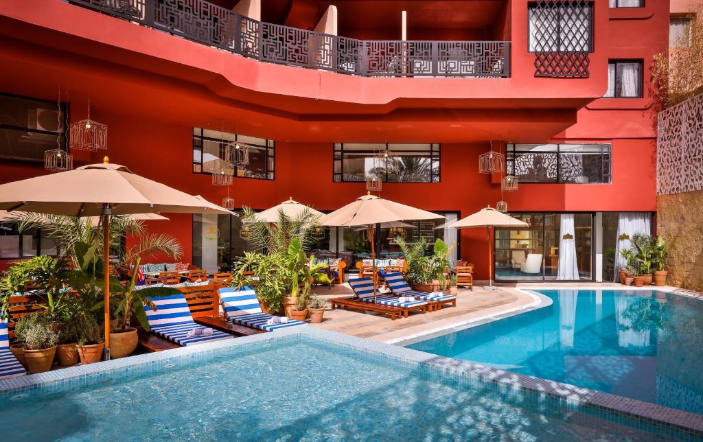 马拉喀什2希尔斯精品酒店的酒店设有带椅子和遮阳伞的游泳池