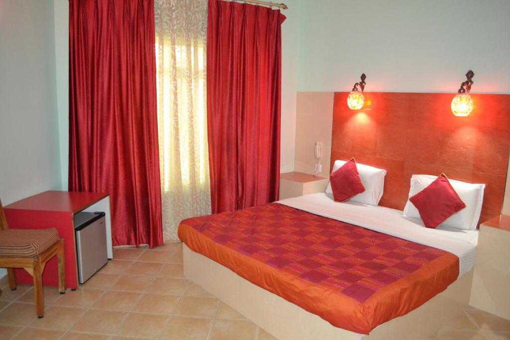 阿格拉雷玛雅酒店的一间卧室配有大床和红色窗帘