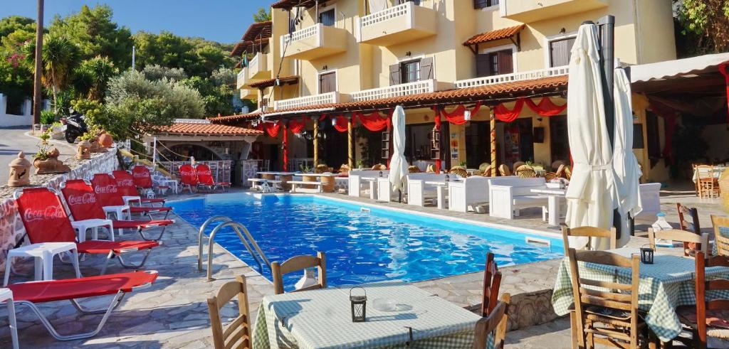斯卡拉瓦萨洛拉斯酒店的一座带桌椅的游泳池位于酒店大楼旁