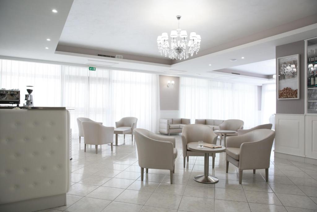 圣乔瓦尼·罗通多里昂酒店及罗索卡瓦利诺餐厅的一间带桌椅和吊灯的用餐室