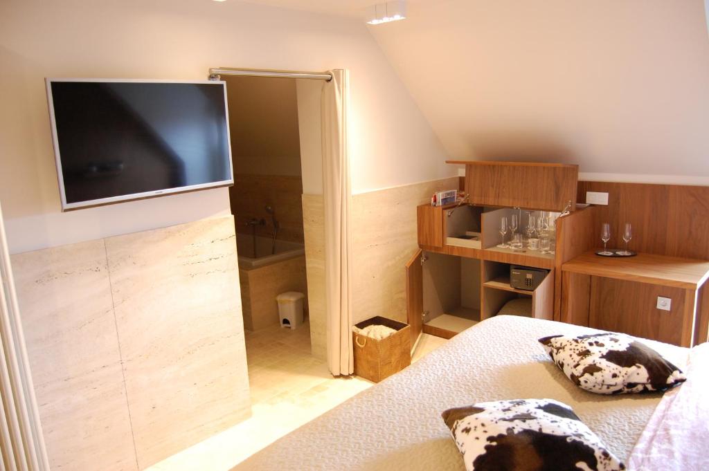 ZandvoordeB&B Cottage Sandfort的一间卧室配有一张床和一台平面电视