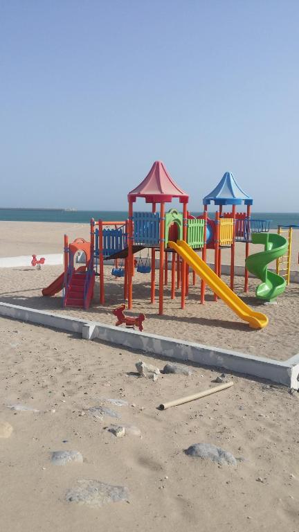 苏尔阿拉菲滨海酒店公寓的海滩上靠近水面的游乐场