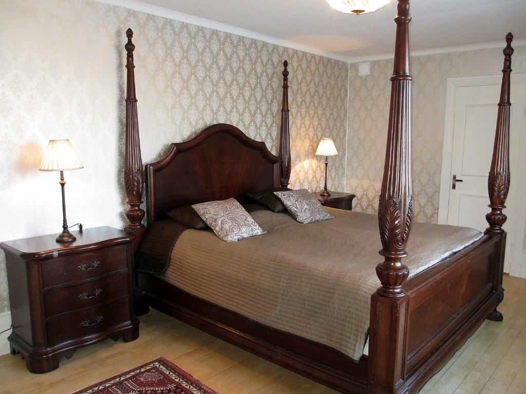 瑟德福什Villa Granvik的一间卧室设有一张大木床和两个床头柜。
