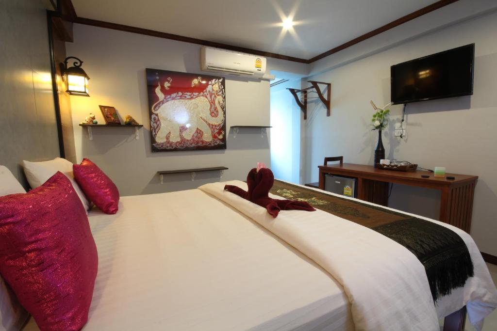 素可泰TR宾馆的卧室配有带红色枕头的大型白色床