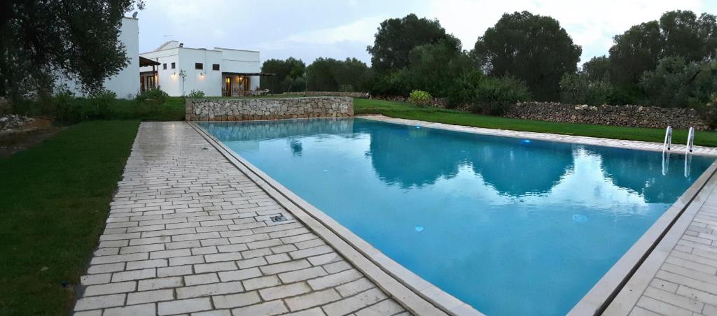 韦列马可尼农家乐的一座带房子的庭院内的游泳池