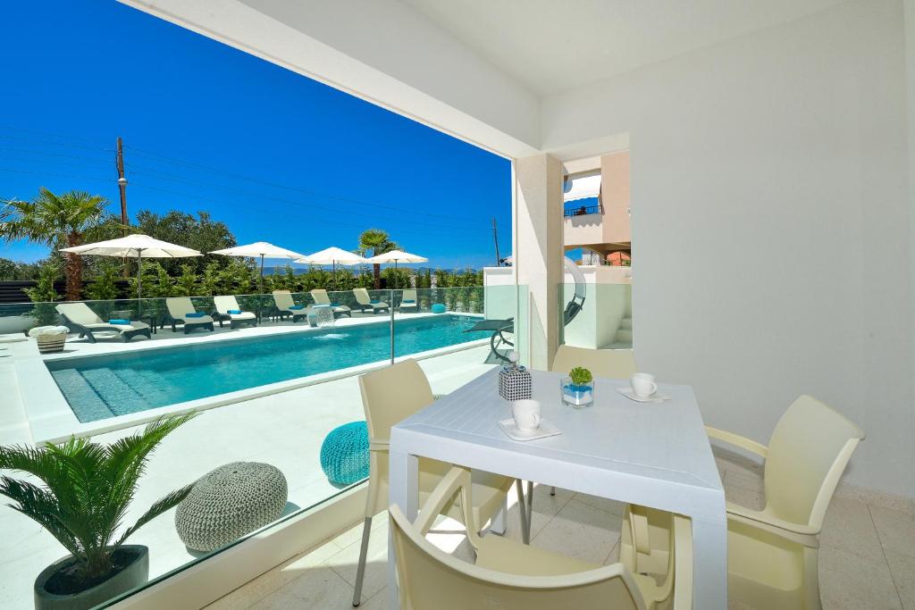 比比涅Luxury Apartment 1 Villa Arta的一间带桌椅的客厅和一个游泳池