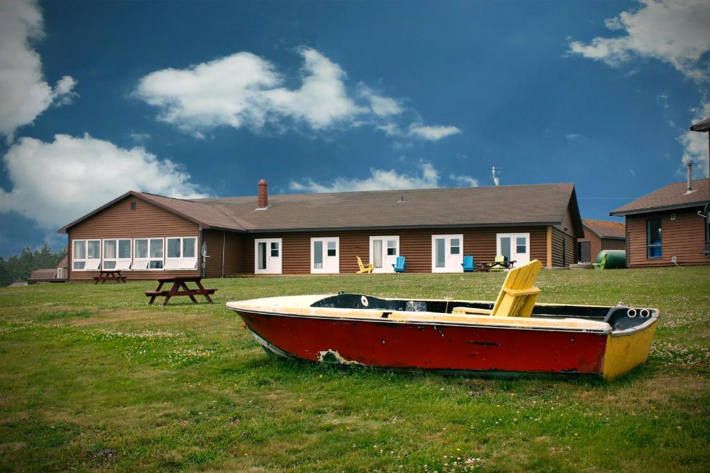 WestportBrier Island Lodge的坐在房子前面的草上的小船