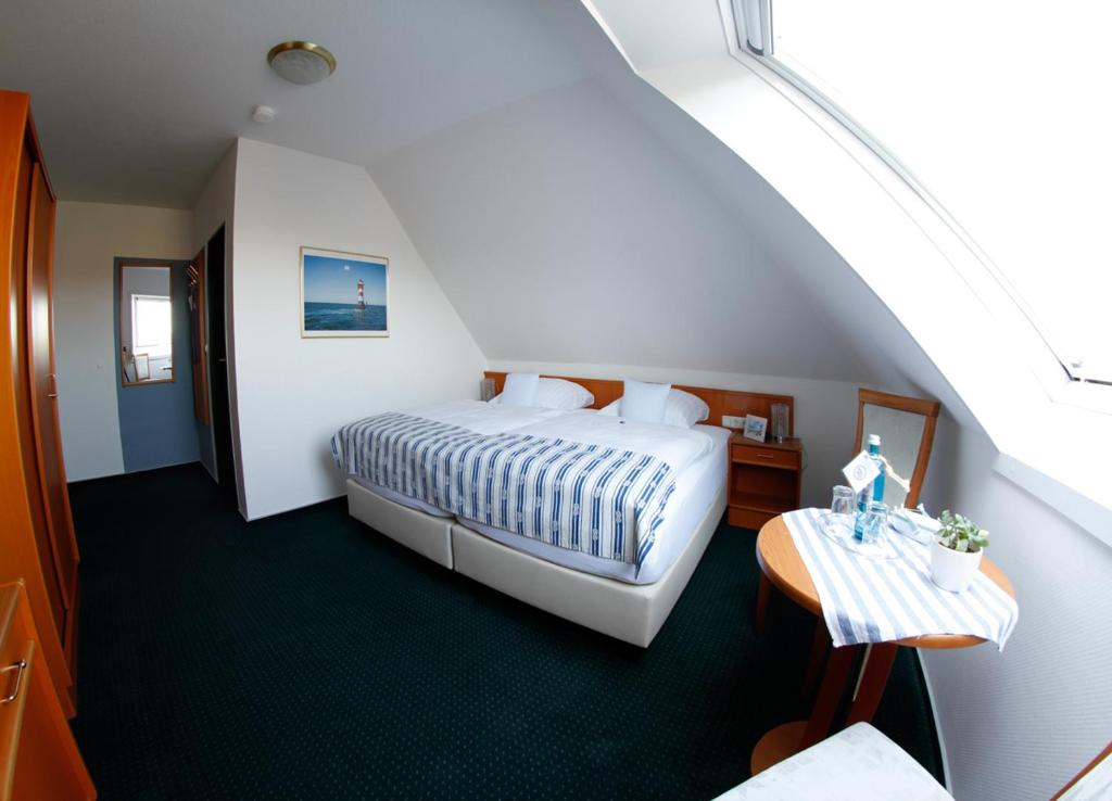 威廉港安科广场加尼酒店的酒店客房配有一张床铺和一张桌子。
