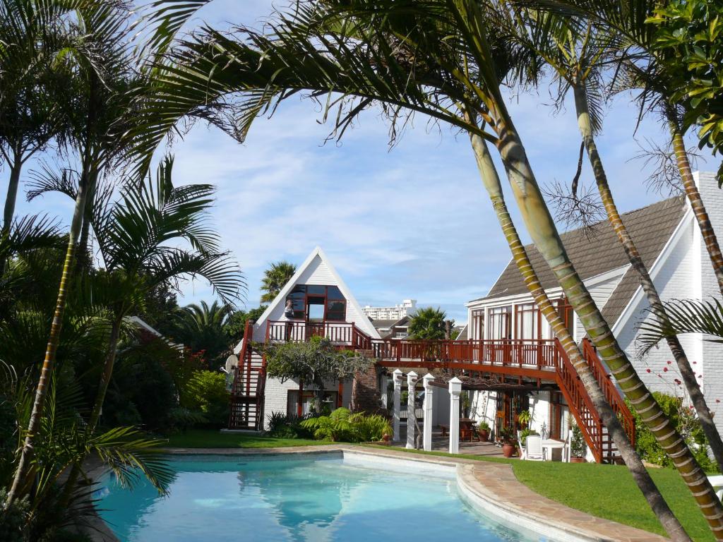伊丽莎白港Aberdour Guesthouse的一座带游泳池和棕榈树的房子