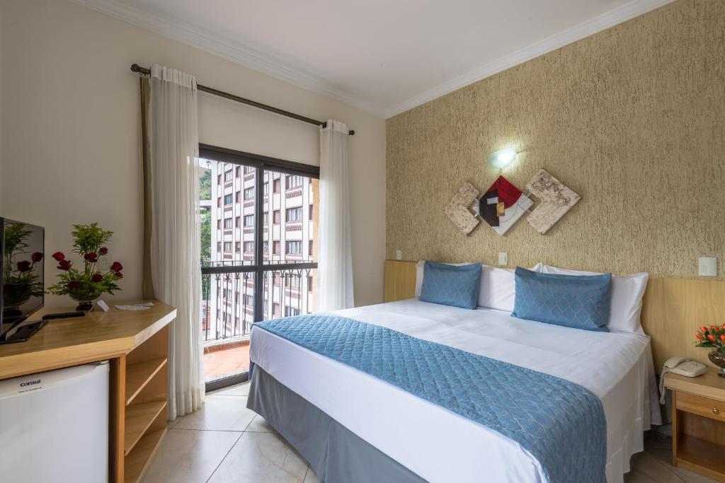 阿瓜斯迪林多亚古亚尔尼酒店的一间卧室设有一张床和一个大窗户