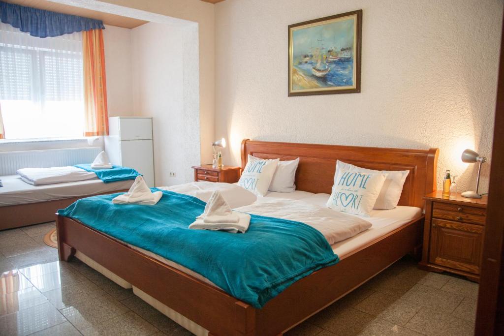 拉姆斯泰因-米森巴赫Hotel Atlantis的一间卧室配有一张带蓝色床单的大床