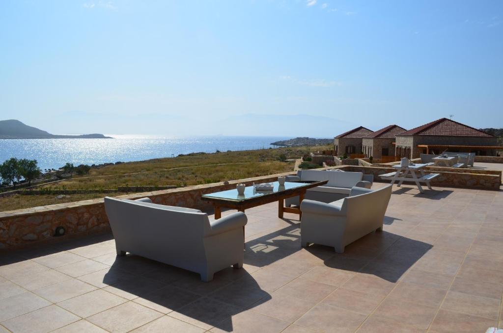 哈尔基岛Villa Aristoteles的一个带桌椅的庭院和大海
