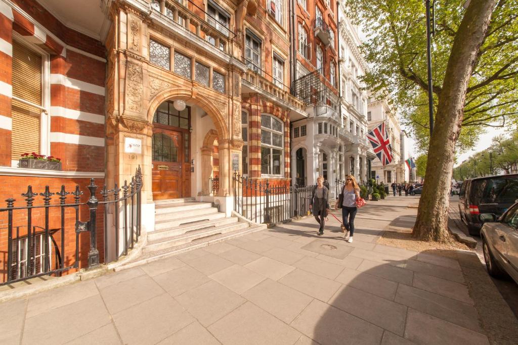 伦敦海德公园阿斯特旅舍的两个人在大楼前的人行道上走