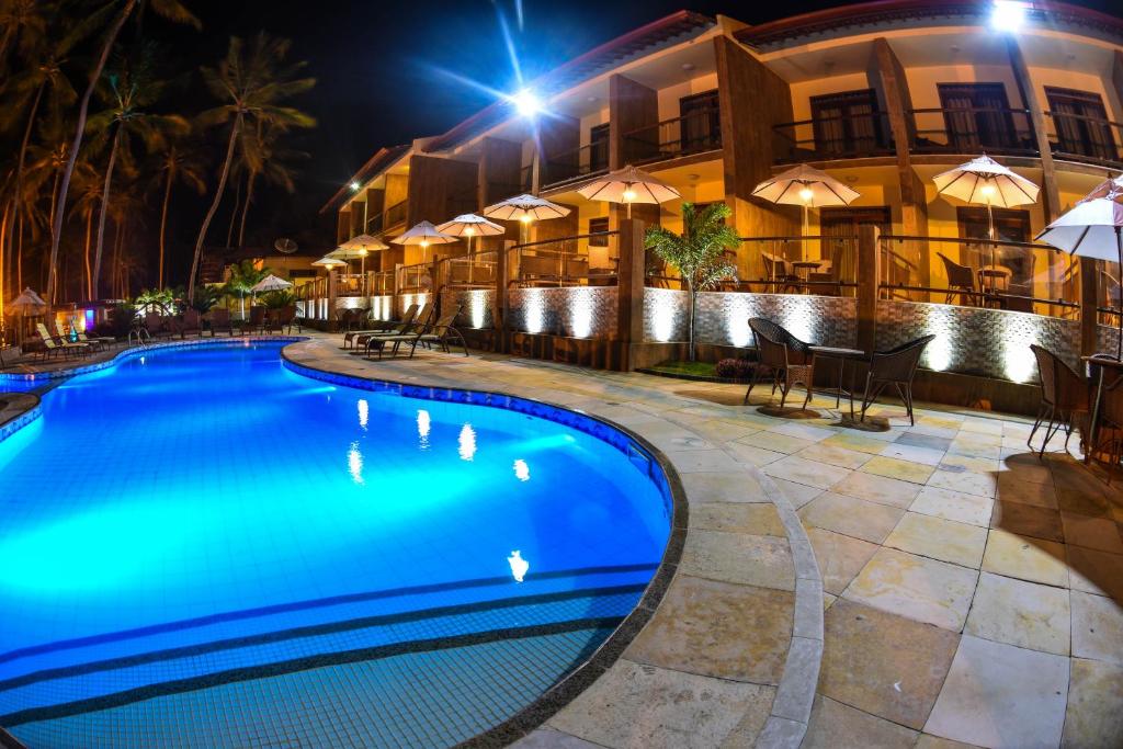 拉戈伊尼亚Genus Beach Hotel的夜间在酒店前的游泳池