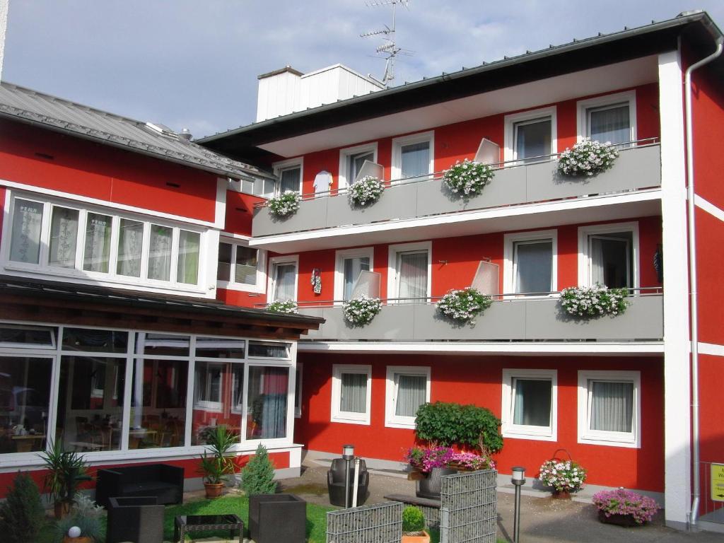 巴特法兴格希尔德加德旅馆的阳台上的红色建筑,种植了盆栽植物