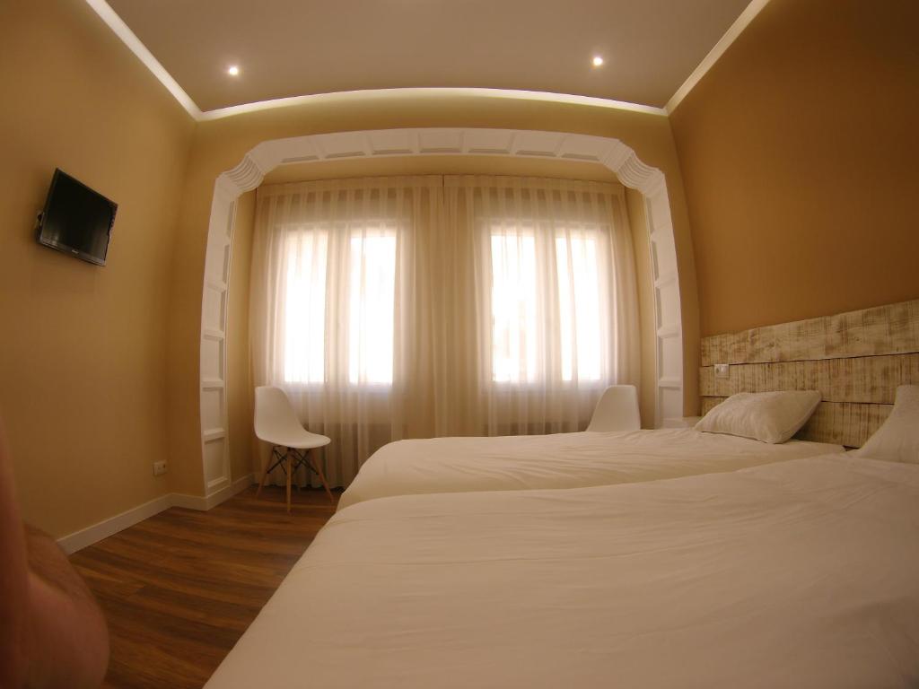 布尔戈斯Urban Burgos的一间卧室设有两张床和窗户。