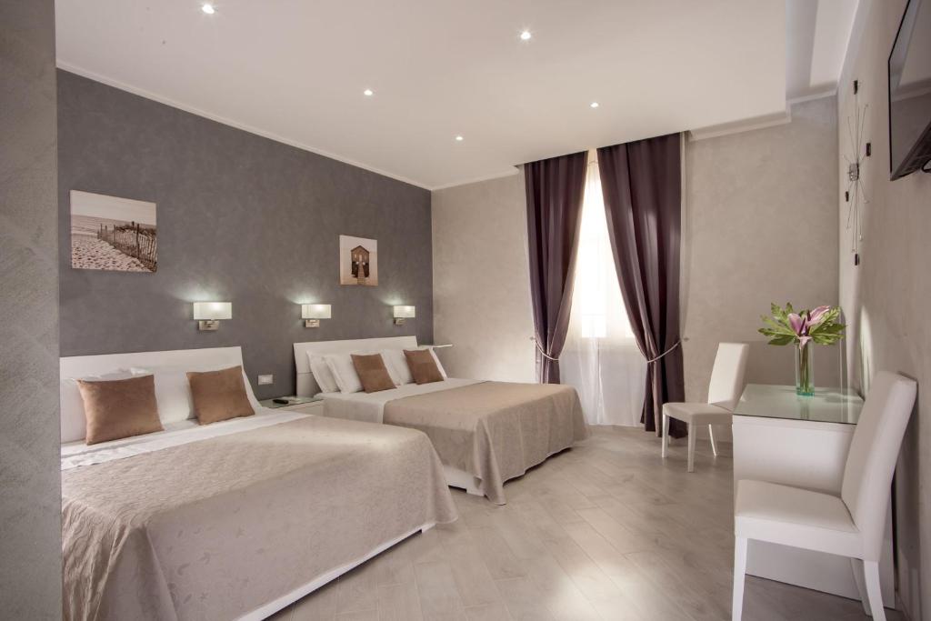 罗马弗拉迪纳华丽套房旅馆的酒店客房,配有两张床和椅子