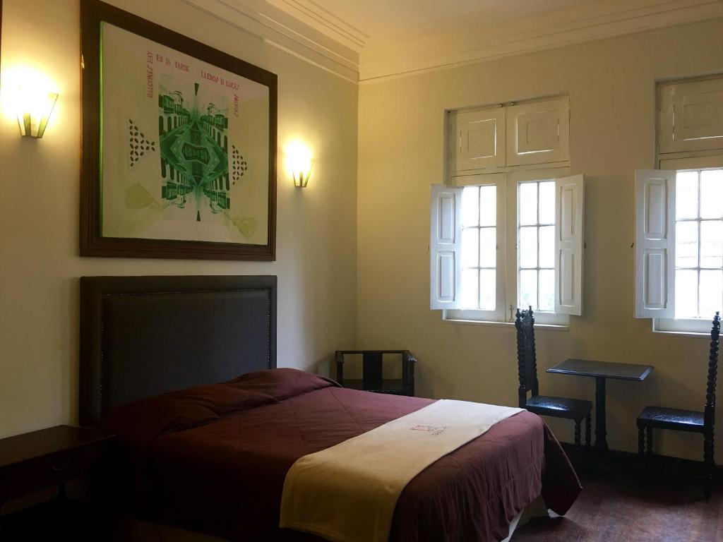 利马Santa Rosa Apartotel- Centro Histórico的一间卧室设有一张床和两个窗户。