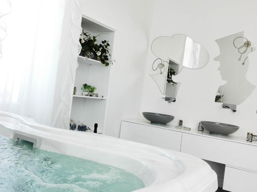 莱切Corte del Pascià的白色的浴室设有浴缸和两个盥洗盆