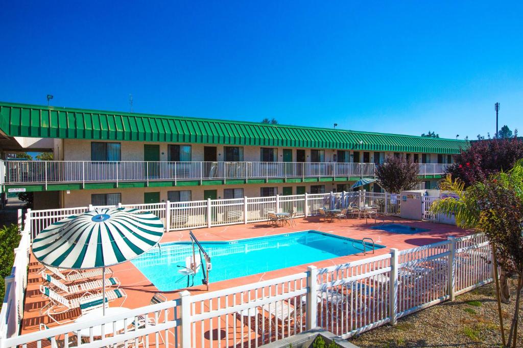 弗雷斯诺弗雷斯诺大学旅馆的一座设有游泳池和遮阳伞的酒店