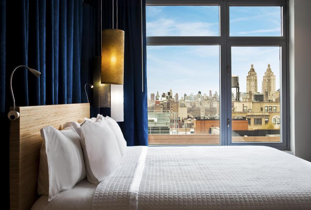 纽约Arthouse Hotel的卧室设有大窗户,享有城市美景。