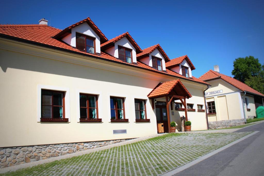 VlasenicePenzion U Rudolfů的白色的建筑,有红色的屋顶和街道