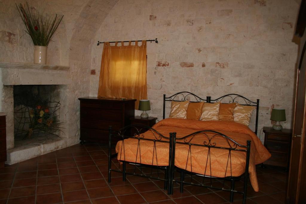 卡斯特拉纳格罗泰Masseria La Luna Nel Pozzo的一间卧室配有一张床和一个壁炉