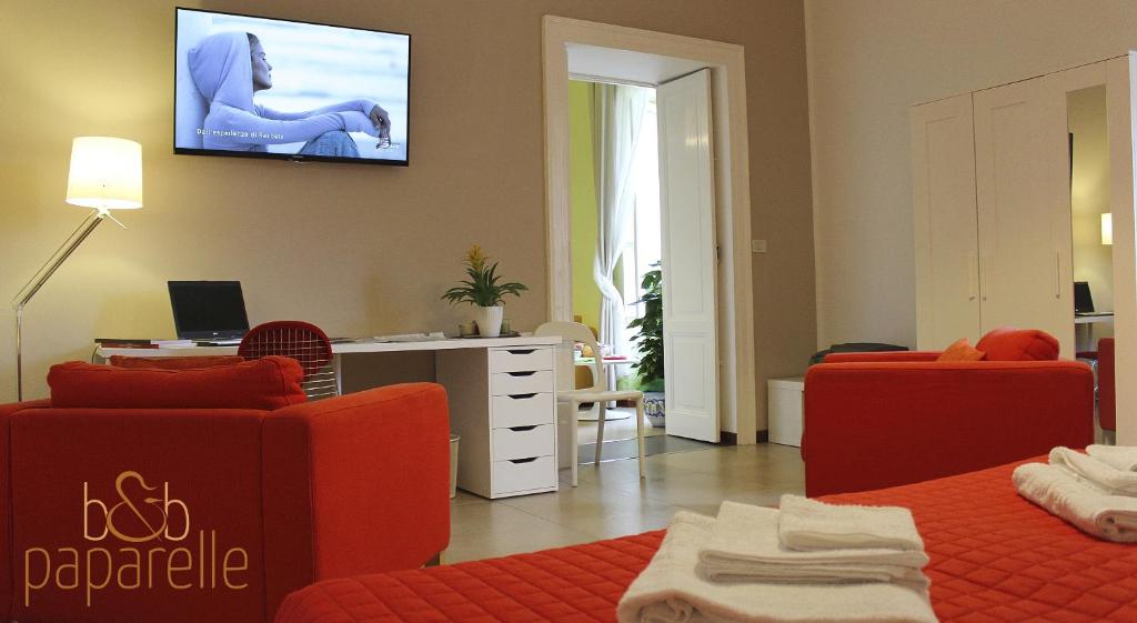 科森扎帕帕尔蕾住宿加早餐旅馆的客厅配有橙色家具和墙上的电视
