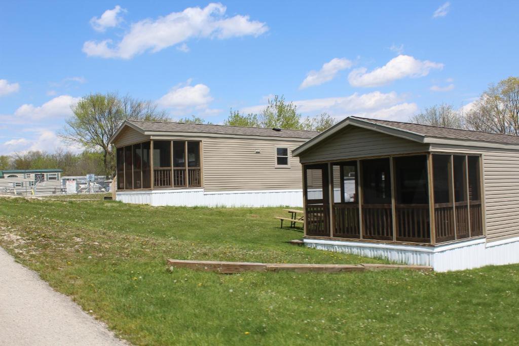 Elkhart LakePlymouth Rock Camping Resort Park Model 21的草场上带门廊的建筑