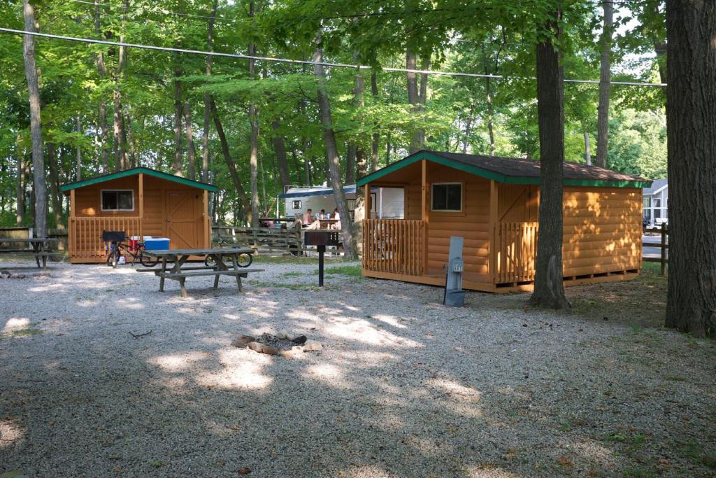 Elkhart LakePlymouth Rock Camping Resort Studio Cabin 2的公园设有2间小屋和1张野餐桌