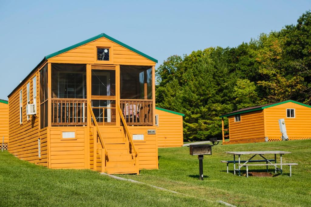 Elkhart LakePlymouth Rock Camping Resort Deluxe Cabin 16的大型小木屋,设有野餐桌